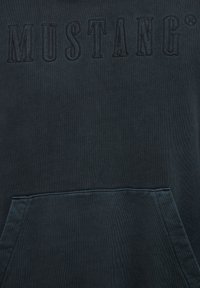 Mørkegrøn hættetrøje med broderet "MUSTANG" logo på brystet og en kangurulomme foran. Blødt materiale med en struktureret overflade.