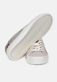 Glitrende sølv sneakers med en hvid gummisål, tekstureret stofoverdel og flade snørebånd. Har en ydersål med chevron-mønster.