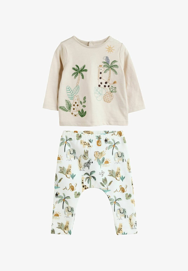 Maglietta a maniche lunghe color beige chiaro con ricami colorati di animali e piante, abbinata a pantaloni bianchi con un motivo a tema giungla in toni smorzati.