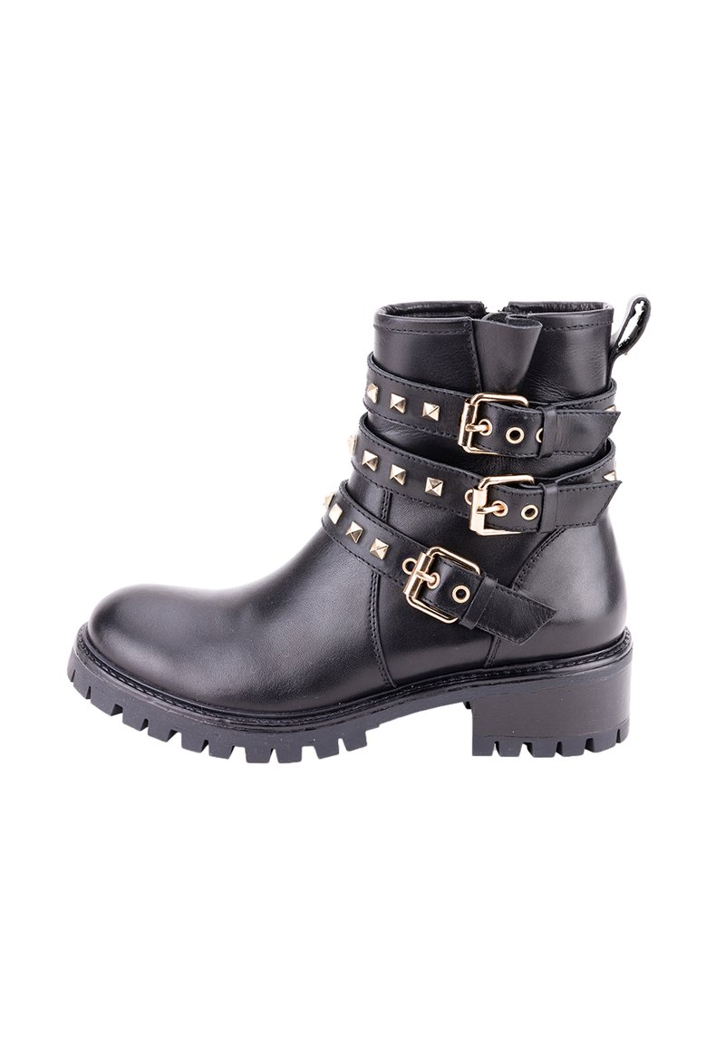 Botín de cuero negro hasta el tobillo con múltiples hebillas en tono dorado y acentos de tachuelas. Presenta una suela robusta tipo lug y un tacón ligeramente elevado.