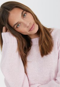 Helles rosa gestricktes Sweatshirt mit Rundhalsausschnitt, gerippten Ärmeln und einem weichen, strukturierten Stoff. Die Passform ist entspannt und komfortabel.