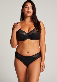 Zwarte kanten beha en bijpassende slip met bloemrijke kantaccenten, een gestructureerd patroon en kleine strikjes in het midden.