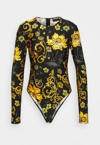 Il bodysuit a maniche lunghe presenta un tessuto nero con motivi floreali gialli e swirl, un collo rotondo e una chiusura con zip sul retro.