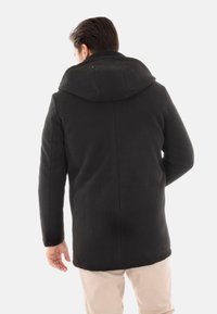 Cappotto in pile con fodera in pelliccia, dotato di un ampio cappuccio, taglio dritto e design minimalista. Copertura completa con texture liscia e cuciture nascoste.