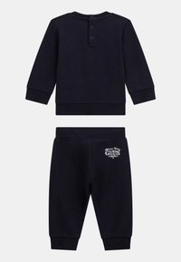 Marineblauer Baumwoll-Trainingsanzug mit einem langärmeligen Oberteil mit Knopfdetails und passenden Hosen mit einem Logo-Akzent an der Seite.