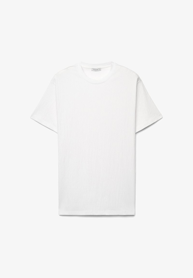 T-shirt uni blanc à manches courtes et col rond, en tissu texturé, présenté à plat sur un fond blanc.