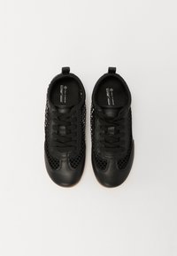 Schwarze vegane Schuhe aus einer Kombination von glattem Leder und Mesh-Gewebe, mit Schnürsenkeln und einer Zuglasche für einfaches Anziehen. Abgerundete Zehenform.