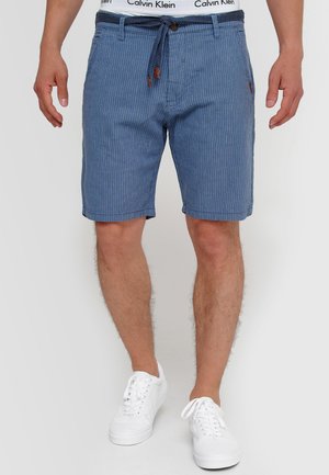Blaue gestreifte Shorts mit einem Kordelzugbund, aus weichem Stoff gefertigt. Sie verfügen über vertikale Streifen und ein kleines Logo auf der Vorderseite der Tasche.