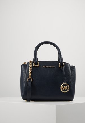 Zwart gestructureerde leren handtas van Michael Kors met gouden accenten, dubbele handvatten, afneembare riem en ronde MK-logo hanger aan de voorkant.