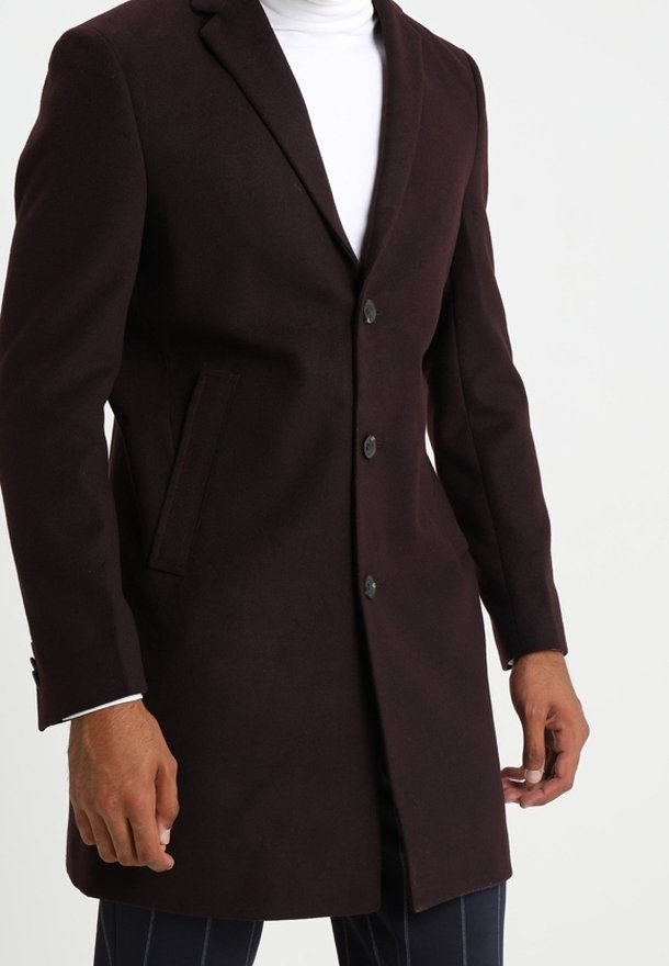 Abrigo de lana burdeos con un diseño entallado, cuello con muescas y dos botones. Cuenta con bolsillos laterales y una textura suave, adecuado para ocasiones formales.