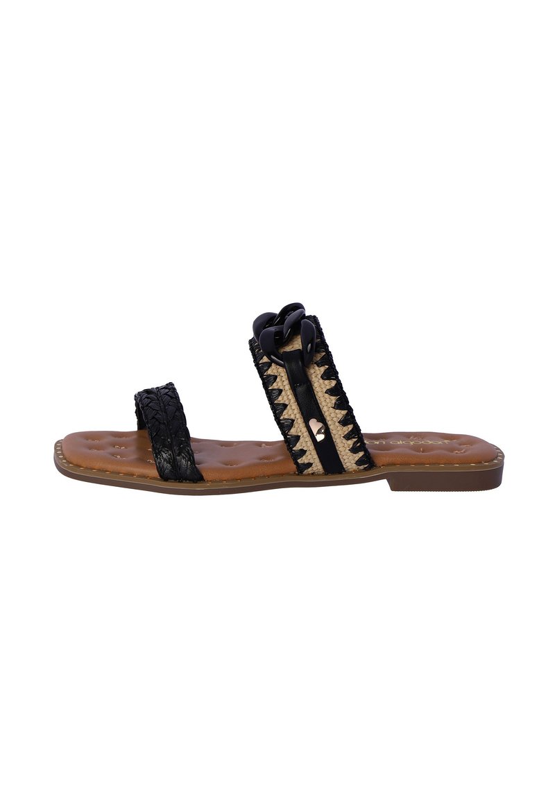 Chancla de tiras tejidas en negro y natural, con dos correas, plantilla acolchada de color marrón y adornos decorativos en la parte superior.