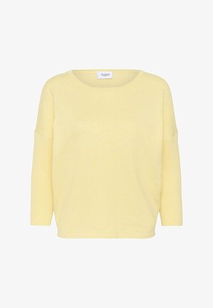 Svetložltý pletený sveter s dlhými rukávmi, zaobleným výstrihom a voľným strihom, s malou značkovou etikietou „Saint“ vo vnútri goliera.