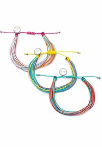 Tre braccialetti di corda multicolore con nodi regolabili e piccoli charm rotondi in argento su uno sfondo bianco.