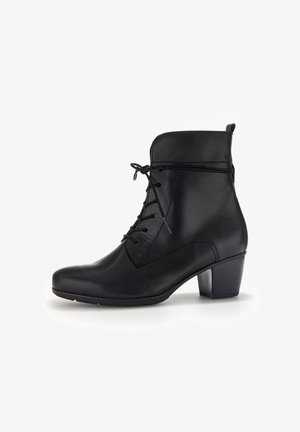 Bottine en cuir noir avec un bout arrondi, un laçage et un petit talon carré. Texture lisse et détails de couture simples.