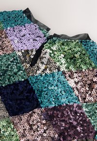 Flerfärgat paljettmaterial med rutor i nyanser av grönt, blått, lila och svart. Mjuk, glänsande textur med ett varierat färgspektrum.