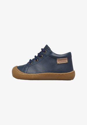 Scarpa da bambino in pelle blu navy con suola in gomma marrone, lacci blu navy e un'etichetta del marchio "Barefoot" sul lato.