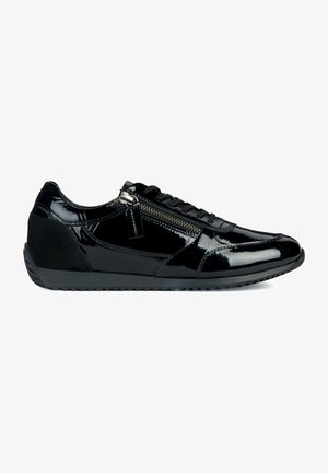 Zapato bajo de licra negro con cordones, cremallera lateral y suela de goma texturizada, visto desde el lado exterior.