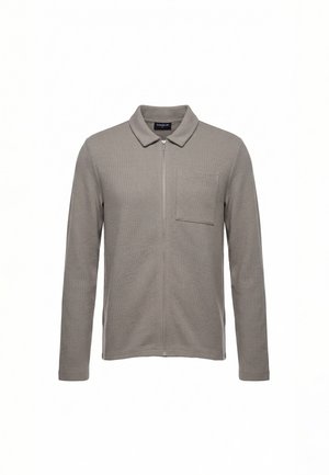 Pilka ilgomis rankovėmis, užsegama užtrauktuku su apykakle ir krūtinės kišene, pagaminta iš tekstūruotos medžiagos, pristatyta ant balto fono.