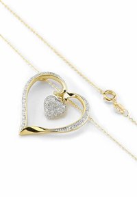 Collana con ciondolo a forma di cuore in tonalità dorata con un cuore più piccolo incastonato di pietre trasparenti, finitura liscia e chiusura a moschettone su una catena delicata.