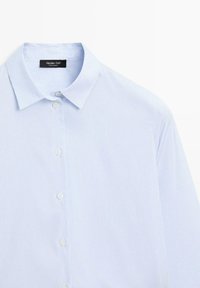 Camicia azzurra a righe con bottoni, realizzata in cotone. Caratterizzata da un colletto classico, bottoni bianchi e una consistenza liscia.