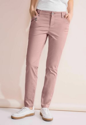 Pantalons en mélange de coton rose avec une coupe slim, dotés d'une poche zippée à l'avant, de passants de ceinture et d'un bouton de fermeture. Associés à des baskets blanches.