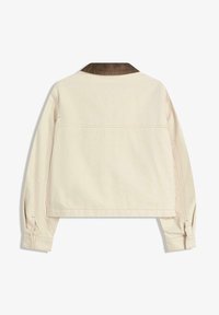 Lyhyt takki off-white kankaasta, jossa on samettinen kaulus. Edessä pitkät hihat, joissa on napitettavat hihansuut, sekä näkyvät ompeluskoristelu.