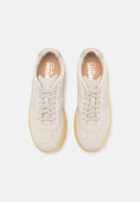 Ljusbeige sneakers med en mockakänsla, med en stickad design, rund tå och sula i gummi. Snörning och vadderad krage ingår.