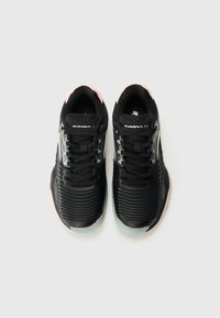 Czarne buty sportowe z żeberkowaną teksturą i sznurowadłami. Jasnoróżowe akcenty na pięcie. Odblaskowe detale po bokach. Okrągły nos.