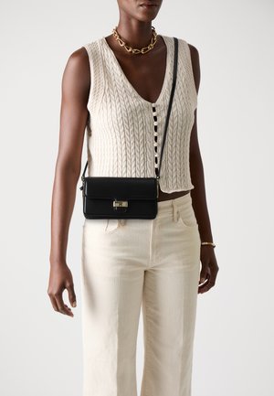 Black leather crossbody bag with a clasp closure, rectangular shape, and a long strap, displayed against a neutral background.