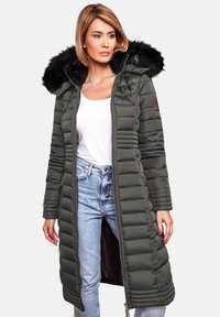 Long, olive green puffer coat with zip closure, quilted design, fur-lined hood, side pockets, and a slim fit, paired with light blue jeans.
