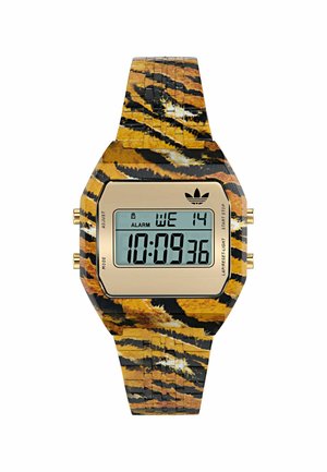 Digitális óra arany színű LCD-képernyővel, sárga és fekete tigriscsíkos mintájú szíjjal, valamint arany színű kezelőgombokkal az oldalakon.