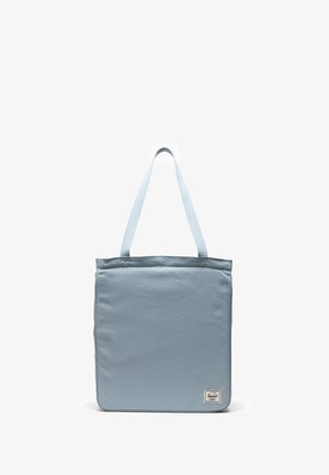 Lichtblauwe totebag van stevig stof, met twee handvatten en een gestikte logo-patch in de rechter benedenhoek.