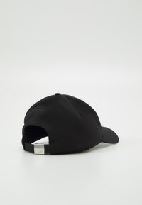 Sort baseball cap med buet skygge, justerbar rem bagpå og ventilationshuller. Lavet af blødt stof med en glat tekstur.