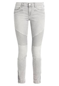 Grey denim skinny jeans featuring ribbed knee accents and a fitted design. Includes front pockets and zippers at the ankle.
