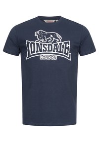 Tengerészkék pamut póló, kerek nyakkivágással. Jelen van rajta egy fehér grafika egy oroszlánról, valamint a "Lonsdale London" felirat, jól láthatóan.