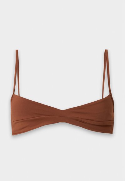 Καφέ μινιμαλιστικό bralette με λεπτές ρυθμιζόμενες τιράντες και ελαφρύ σούρωμα στο κάτω κέντρο σε απλό φωτεινό φόντο.