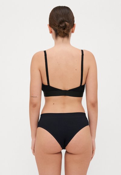Melna bralette ar regulējamām siksnām un atbilstošām augstām biksītēm. Mīksts, elastīgs materiāls ar gludu tekstūru un minimālistisku dizainu.