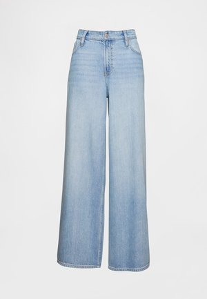 Lichtblauwe jeans met wijde pijpen van denimstof. Heeft een hoge taille, ritssluiting en twee voorzakken met zichtbare stiksel details.