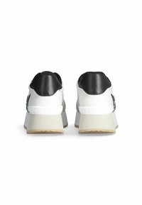 Sneakers platform bianchi e neri con tacco nero testurizzato, caratterizzati da una parte superiore bianca liscia, dettagli del logo in rilievo e suola in gomma.