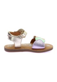 Sandalias metálicas doradas con suela plana, que cuentan con un cierre de hebilla y detalles en capas de colores en la puntera, incluyendo verde y púrpura.