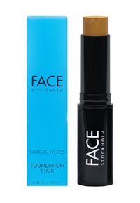 Foundationstick in zwarte verpakking met een gouden productpunt, vergezeld van een blauwe doos met het label "FACE STOCKHOLM" en "NORDIC NOTES."