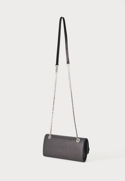 Sac à épaule rectangulaire noir avec anse chaîne argentée et coussinet d'épaule en cuir noir sur fond uni.