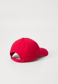 Punainen baseball-hattu, jossa on kaareva lippa, säädettävä hihna ja kuusi ilmanvaihtoreikää. Valmistettu kestävästä kankaasta, jossa on sileä rakenne.
