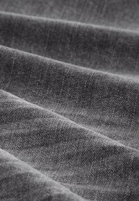 Tela de un gris oscuro con un tejido texturizado, que muestra capas dobladas que crean una apariencia suave. Variaciones sutiles en el tono realzan la profundidad.