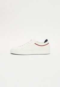 Sneaker bianco con tomaia in maglia texturizzata, strisce accentate rosse e blu, punta tondeggiante e suola piatta in gomma. Lacci per una vestibilità sicura.