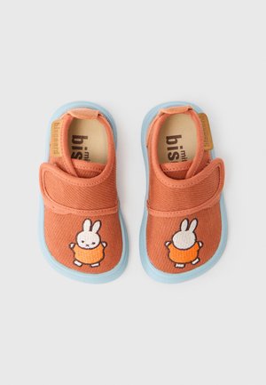 Kinderschuhe in Orange mit blauen Sohlen, Klettverschluss-Riemen und einer Stickerei eines Hasen, abgebildet von vorne und hinten.