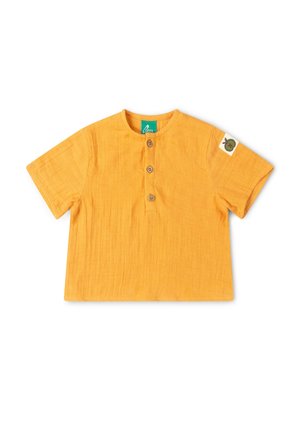 Gelbes kurzärmeliges Kleinkindshirt mit rundem Halsausschnitt, drei Holzknöpfen vorne und kleinem Aufnäher mit grünem Apfel auf dem linken Ärmel.