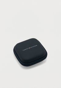 Συμπαγές μαύρο τετράγωνο θήκη με φερμουάρ και στρογγυλεμένες γωνίες, με το λογότυπο Tommy Hilfiger σε λευκό και κόκκινο στο πάνω μέρος.