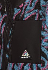 Veste en polaire avec une poche poitrine texturée noire. Présente un motif abstrait bleu, rose et noir, ainsi qu'un patch logo O'Neill.