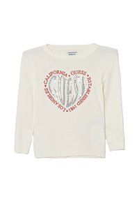 Maglione color crema con collo rotondo, caratterizzato da un design a cuore argentato luccicante al centro e testo rosso attorno ad esso.